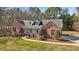 Charming exterior of red brick home with dormer windows, front porch and landscaped yard at 211 Garden W Walk, Hampton, GA 30228