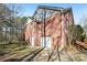 Rear exterior featuring brick, an attached garage, and a view of the wooded backyard at 211 Garden W Walk, Hampton, GA 30228