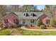 Charming exterior of red brick home with dormer windows, front porch and landscaped yard at 211 Garden W Walk, Hampton, GA 30228