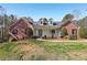 Charming brick home featuring a covered front porch, dormer windows, and a well-manicured lawn at 211 Garden W Walk, Hampton, GA 30228