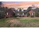 Charming front exterior with brick facade, dormers, white trim, and a well manicured lawn at 211 Garden W Walk, Hampton, GA 30228