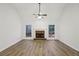 Large living room featuring a brick fireplace, beautiful wood flooring, and natural light at 211 Garden W Walk, Hampton, GA 30228