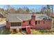 View of the rear exterior of the red brick home, highlighting the screened in porch and wooden deck at 211 Garden W Walk, Hampton, GA 30228