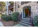 View of an entrance to the building with stone accents and wood steps leading up to the door at 301 Madison Se Ct # 301, Smyrna, GA 30080