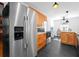 Open kitchen design with stainless steel refrigerator, black tile flooring, and wooden cabinets at 3140 Westmart Ln, Atlanta, GA 30340