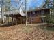 View of the back exterior showcasing a deck, brick foundation, and upper level wood shingles at 6575 Riley Rd, Cumming, GA 30028