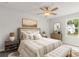 Calm bedroom features a striped comforter, ceiling fan, and large windows at 237 Kindness Cir, Mcdonough, GA 30252