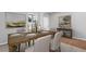 Elegant dining room with a long wooden table, neutral-toned chairs, and artwork on the walls at 237 Kindness Cir, Mcdonough, GA 30252