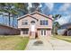 Charming split-level home with a pink exterior, front yard, and a driveway at 6404 Eastbriar Dr, Lithonia, GA 30058