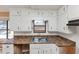Traditional kitchen featuring white cabinets, laminate countertops, and a stainless steel sink at 6404 Eastbriar Dr, Lithonia, GA 30058