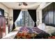 Bright bedroom featuring an accent wall, cityscape views, and a decorative ceiling fan at 3445 Stratford Ne Rd # 2305, Atlanta, GA 30326
