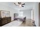 Bedroom with hardwood floors, a bed, ceiling fan, a window, and a dresser with a painting at 12 Saint Georges Pl, Sharpsburg, GA 30277