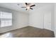 Spacious bedroom featuring hardwood floors, a ceiling fan, and a large window at 12 Saint Georges Pl, Sharpsburg, GA 30277