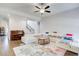 Bright living room with hardwood floors, ceiling fan, and an inviting white sofa set on a floral rug at 12 Saint Georges Pl, Sharpsburg, GA 30277