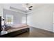 Bright primary bedroom featuring hardwood floors, a ceiling fan, and two windows at 12 Saint Georges Pl, Sharpsburg, GA 30277