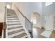 Elegant staircase featuring hardwood steps, white risers and trim, and wrought iron spindles at 12 Saint Georges Pl, Sharpsburg, GA 30277