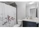 Bathroom with dark wood vanity and white sink next to a tub with a patterned shower curtain at 1918 Coal Pl, Atlanta, GA 30318