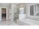 Bright bathroom featuring shower with glass door, soaking tub, and neutral color palette at 1918 Coal Pl, Atlanta, GA 30318