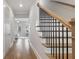 Hallway showcasing beautiful hardwood floors, staircase with iron railings and view into the living area at 1918 Coal Pl, Atlanta, GA 30318