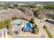 Overhead view of community pool, tennis courts, and clubhouse amidst wooded landscape at 820 Ash St, Canton, GA 30114