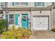 Close up of townhome with teal door, white garage door, and colorful flower wreath at 820 Ash St, Canton, GA 30114