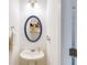 Cozy powder room with decorative mirror, pedestal sink, and neutral paint at 820 Ash St, Canton, GA 30114