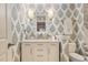 Stylish powder room featuring patterned wallpaper, a marble countertop vanity, and modern sconces at 850 Moores Mill Nw Rd, Atlanta, GA 30327