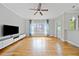 Bright living room featuring hardwood floors, ceiling fan, large window, and modern entertainment center at 1903 Anjaco Nw Rd # 3, Atlanta, GA 30309