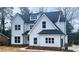 Charming two-story white home featuring black trim, black roof, and manicured landscaping at 2519 Cherry Hill Ln, Atlanta, GA 30360