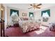 Cozy bedroom featuring a ceiling fan, plush carpet, and bright windows with decorative curtains at 3200 Fence Rd, Dacula, GA 30019