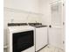 Modern laundry room with front load washer and dryer and geometric tile flooring at 3215 Belford Dr, Marietta, GA 30066