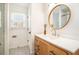 Stylish bathroom with hexagon tile, a wooden vanity, and a modern round mirror at 3215 Belford Drive, Marietta, GA 30066