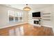 Bright living room featuring a fireplace with a large window, hardwood floors, and floating shelves at 3215 Belford Drive, Marietta, GA 30066