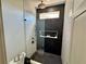 Modern bathroom featuring a glass shower, black marble-style accent wall with a shower niche, and minimalist design at 590 Hood Ave, Fayetteville, GA 30214