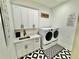 Modern laundry room with front load washer and dryer and ample cabinet storage at 590 Hood Ave, Fayetteville, GA 30214