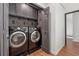 Functional laundry room featuring dark cabinetry, modern appliances, and eye-catching wallpaper at 886 Cedar Creek Se Ct, Marietta, GA 30067