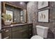 Charming powder room featuring dark vanity, decorative wallpaper, and framed art at 886 Cedar Creek Se Ct, Marietta, GA 30067