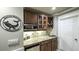 Wet bar featuring a mini fridge, stone countertop, tile backsplash, and brown cabinetry at 9937 Between The Grns, Villa Rica, GA 30180