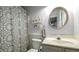 Bathroom featuring a decorative shower curtain, stylish circular mirror, toilet, and vanity with sink at 9937 Between The Grns, Villa Rica, GA 30180