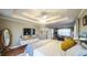 The primary bedroom with hardwood floors, a tray ceiling, and a cozy sitting area at 9937 Between The Grns, Villa Rica, GA 30180