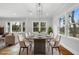 Bright dining room with modern light fixture, large windows, and dining table with seating for eight at 10 Claire Se Dr, Atlanta, GA 30315