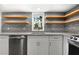 Bright kitchen featuring granite countertops, wooden shelves, and stainless steel appliances, providing a modern and functional space at 10 Claire Se Dr, Atlanta, GA 30315
