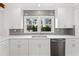 Bright kitchen featuring white cabinetry, stainless steel appliances, granite countertops, and backsplash at 10 Claire Se Dr, Atlanta, GA 30315