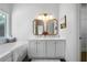 Bathroom with double sink vanity, modern mirrors, and large soaking tub at 3047 Standing Rock Ct, Lithia Springs, GA 30122