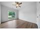 Bright bedroom features wood floors, ceiling fan, and a large window with views of the outdoors at 3047 Standing Rock Ct, Lithia Springs, GA 30122