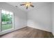 Bedroom with wood floors, ceiling fan, and a large window, providing ample natural light at 3047 Standing Rock Ct, Lithia Springs, GA 30122