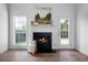 Living room fireplace with windows, decor, and an exterior door showcasing a bright and open space at 3047 Standing Rock Ct, Lithia Springs, GA 30122