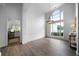 Open-concept living room with lots of natural light from large windows, chandelier, and wood-look floors at 3047 Standing Rock Ct, Lithia Springs, GA 30122