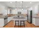 Bright kitchen features white cabinetry, stainless steel appliances, and a central island with bar seating at 4305 Kendall Way, Roswell, GA 30075