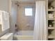 Bright bathroom with white tile, shower-tub, sleek fixtures, and storage shelves for a clean, organized feel at 449 Clairemont Ave # E1, Decatur, GA 30030